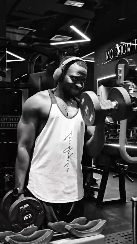 Lamin doing a dumbbell curl, black and white