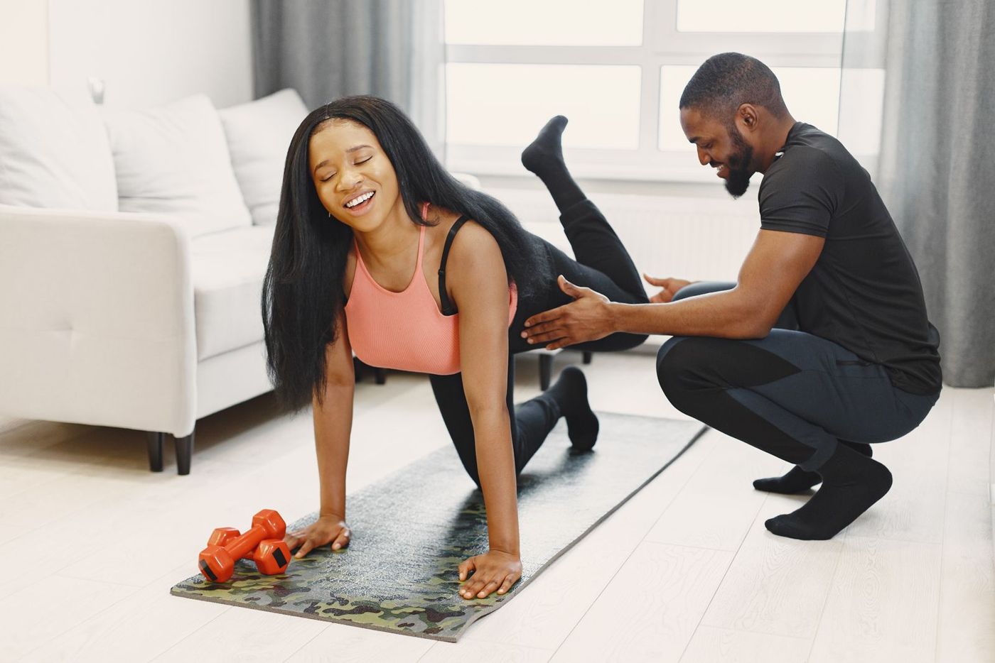 A man and woman training on mats at home